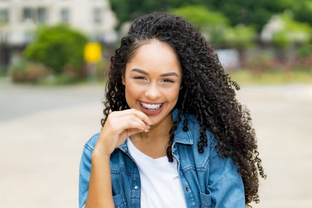 Teen girl smiling with braces at Imagine Orthodontics.