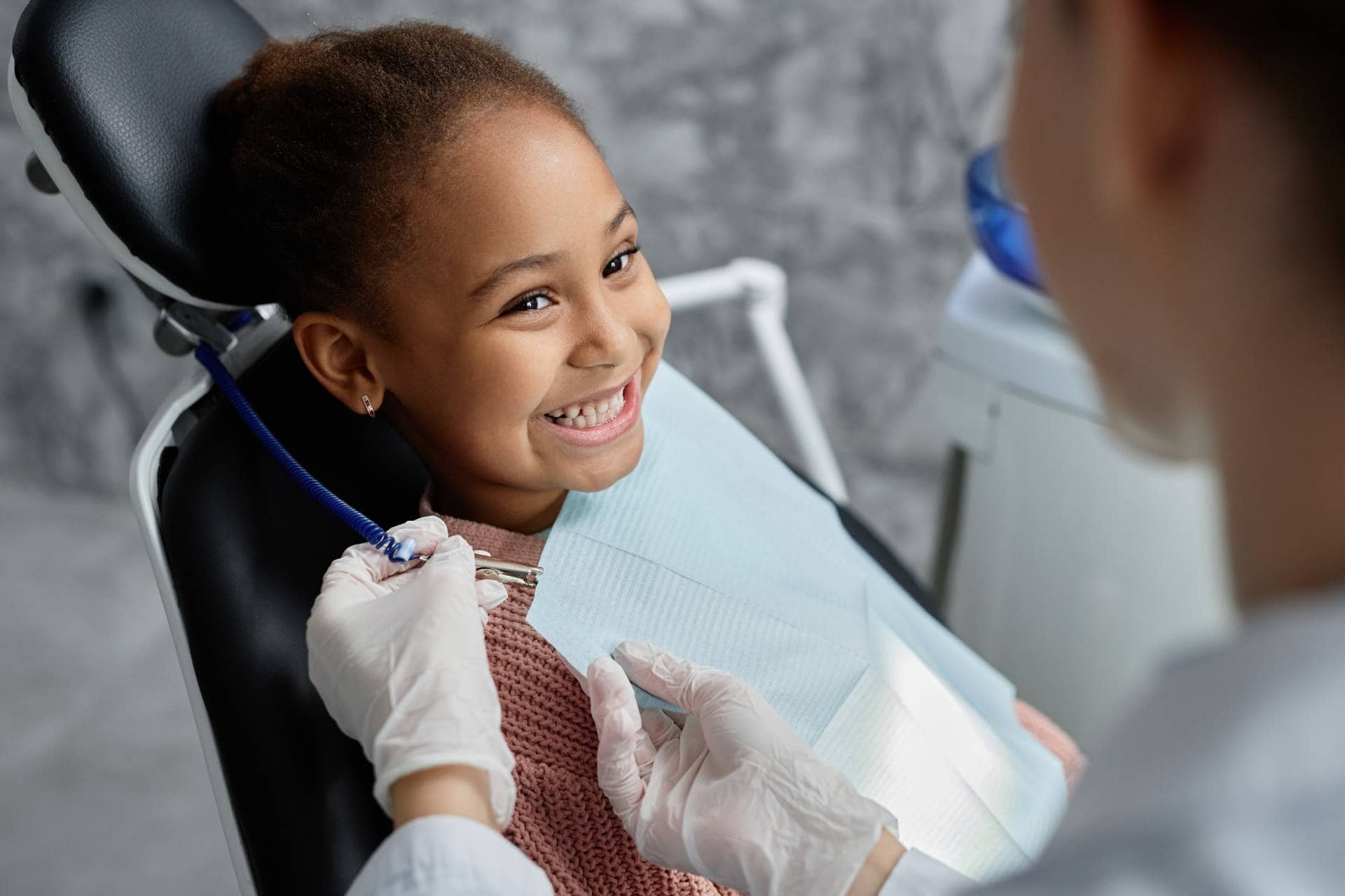Young girl smiling at Imagine Orthodontics in a orthodontic chair.